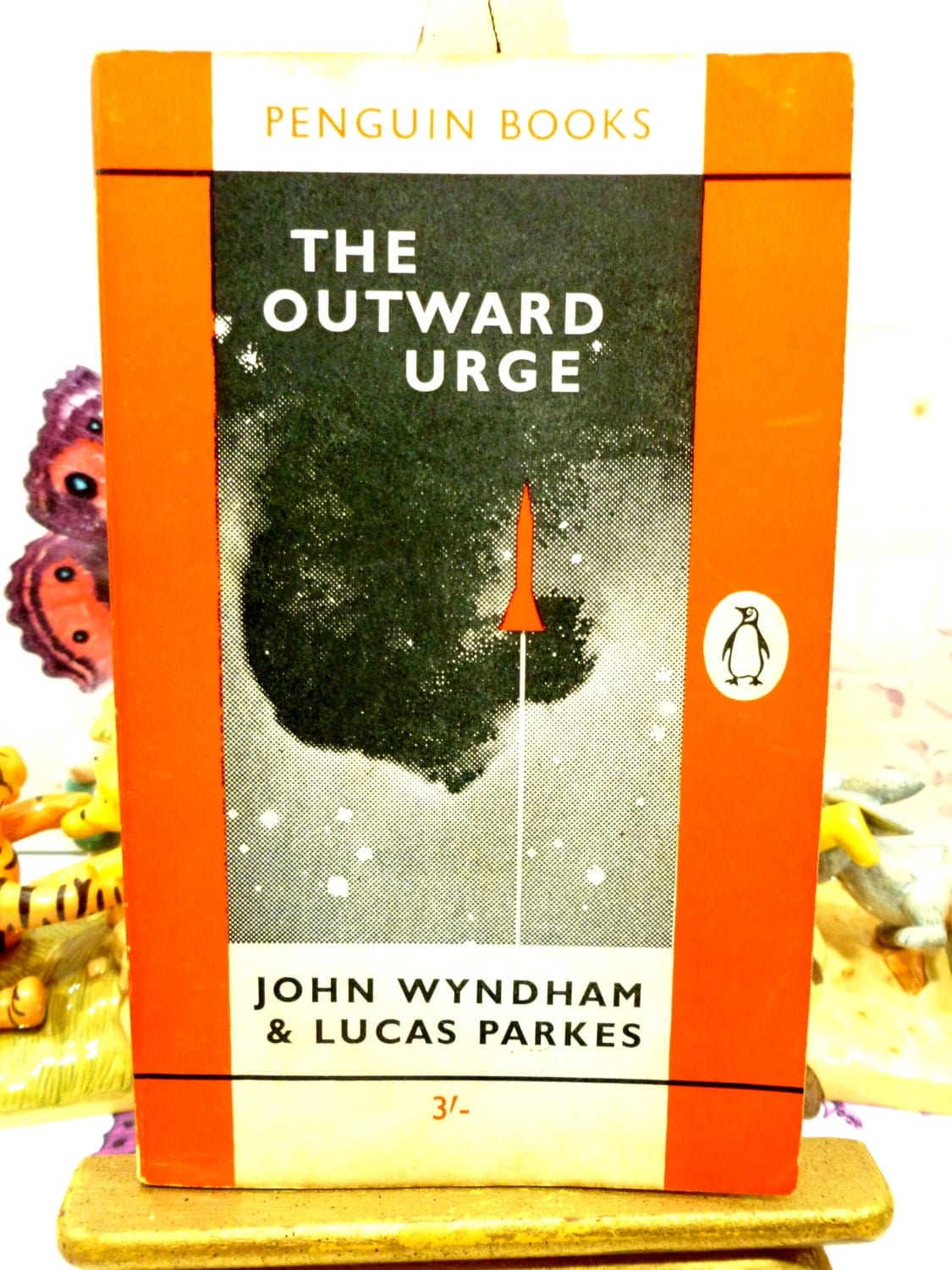 Front cover in orange with space rocket image of The Outward Urge Vintage Penguin Orange Paperback Book. John Wyndham Classic Sci Fi.