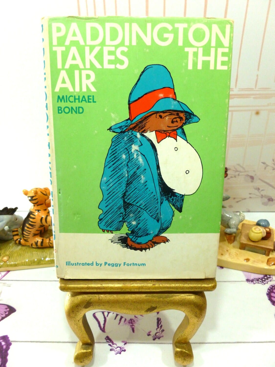 Front cover of Paddington Takes the Air Vintage Book First American Edition with Dust Jacket showing Paddington Bear in Tuxedo against a green ground. 