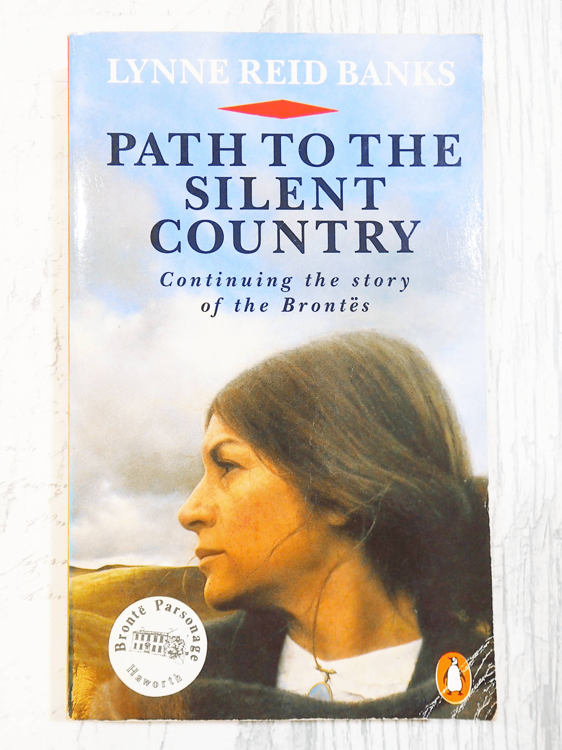 Front cover of vintage Bronte interest book  'Path to the Silent Country' by Lynne Reid Banks - showing a wistful woman gazing over the moors. 