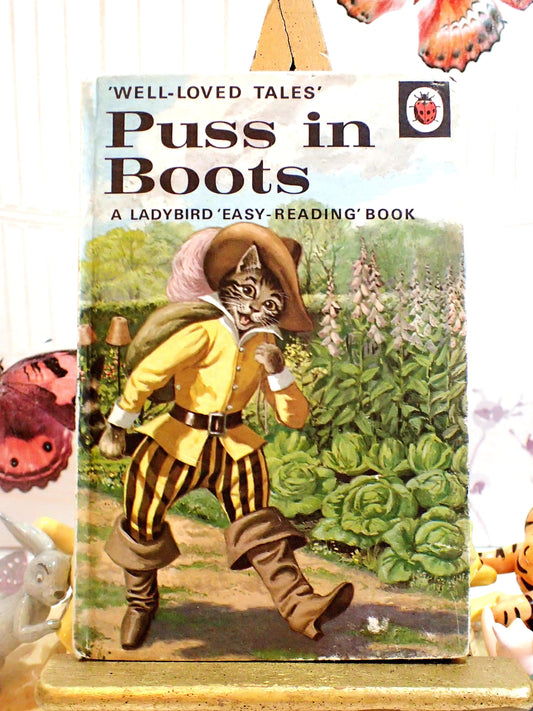 Ladybird Well Loved Tales Puss in Boots chldren's book front cover showing Puss in Boots striding along wearing a hat. 