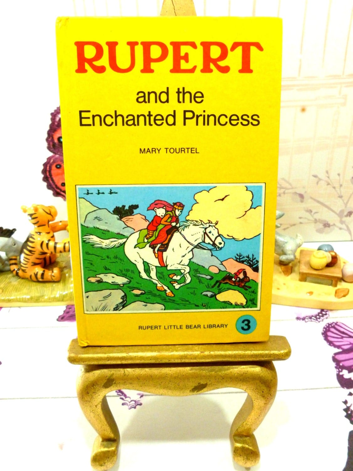 Front cover showing Rupert and the Enchanted Princess riding a horse on Mary Tourtel Little Bear Library number 3 1970s Vintage Hardback Rupert Book First Edition.