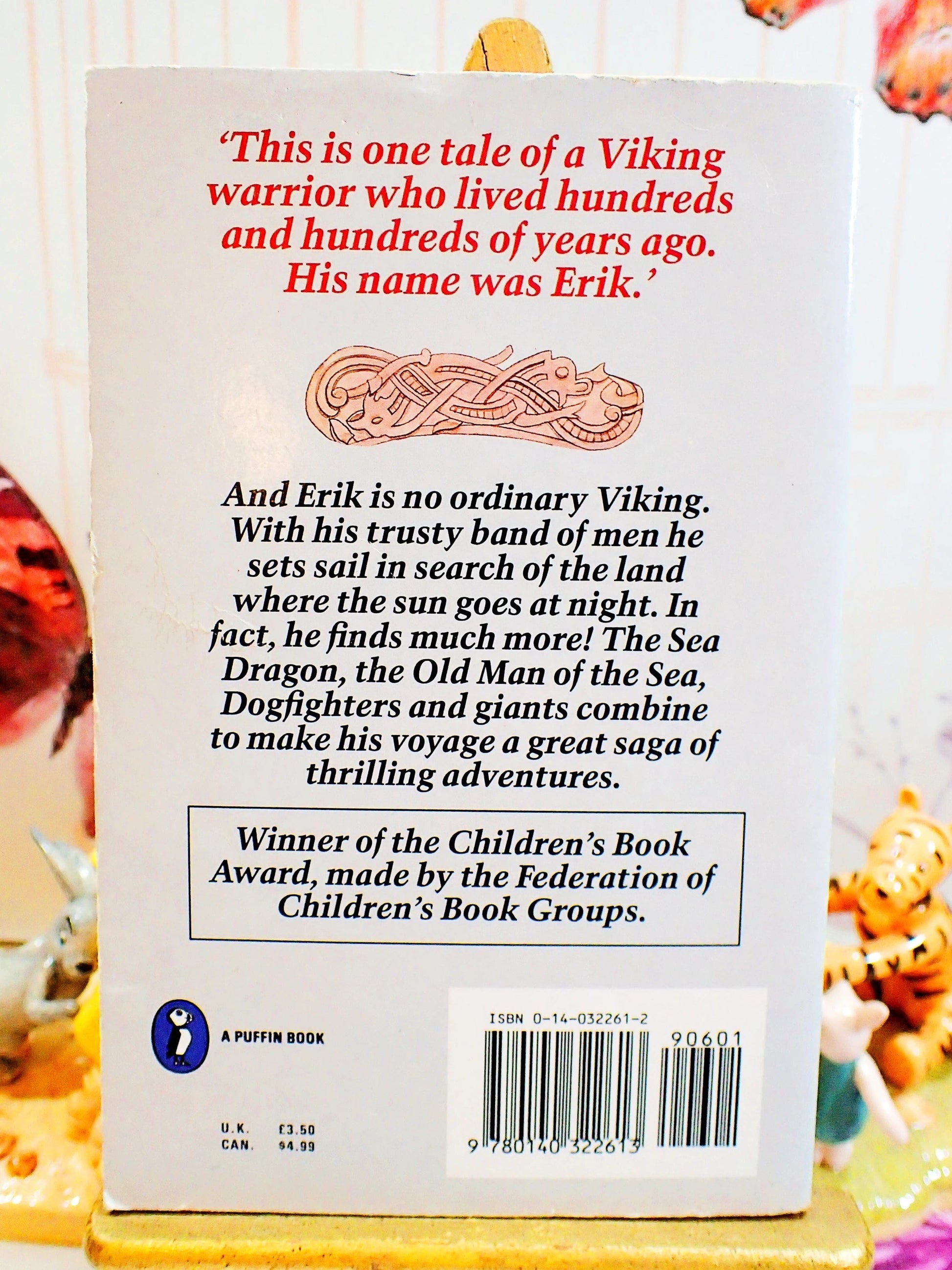 Back cover of The Saga of Erik the Viking by Terry Jones Vintage Puffin Children's Book 1988 showing a Viking Ship sailing against a grey ground with celtic ornamentation. Text: This is one tale of a Viking warrior who lived hundreds...
