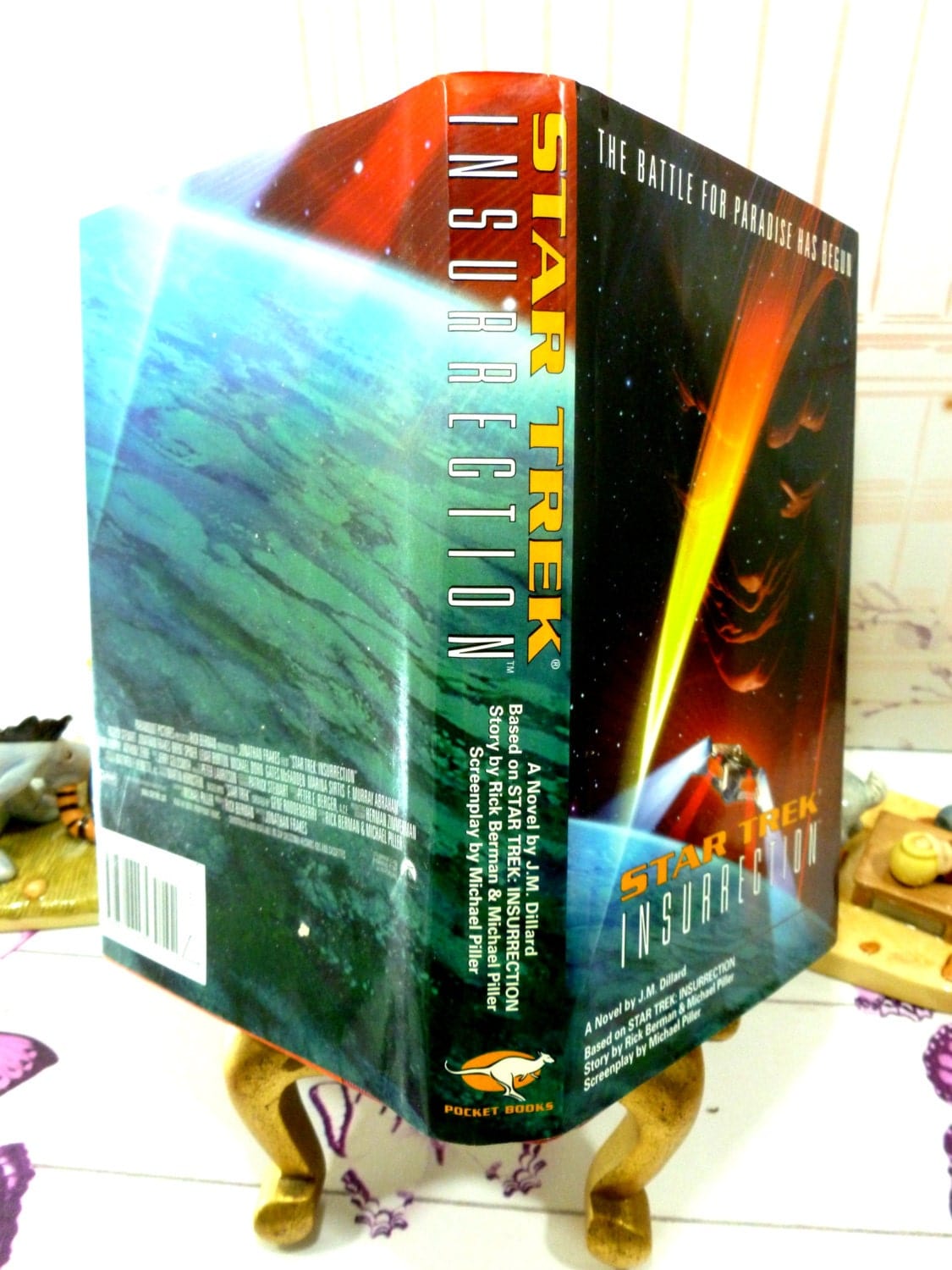 Full wrap dust jacket of vintage book showing space scene and monstrous face looking at the Star Ship Enterprise. Star Trek Insurrection First Edition1st Print Star Trek Novel Pocket Books 1998