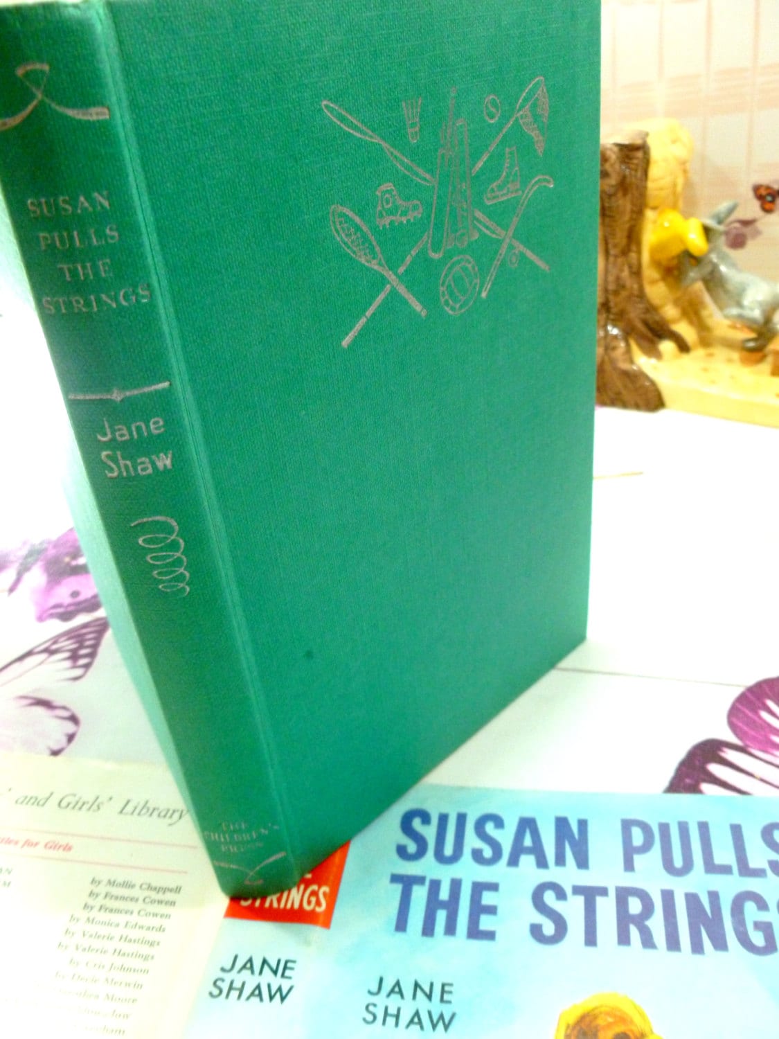 Green clothbound boards with silver titles of Susan Pulls the Strings by Jane Shaw Vintage Hardback book with DW Susan Stories The Childrens Press 1960's.