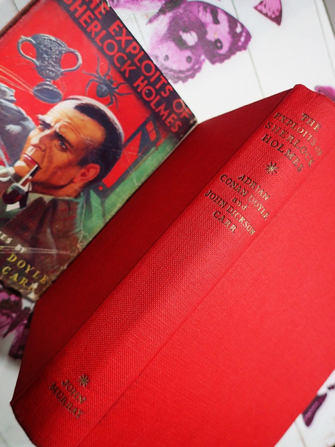 Red cloth binding of The Exploits of Sherlock Holmes Conan Doyle First Edition Vintage Book