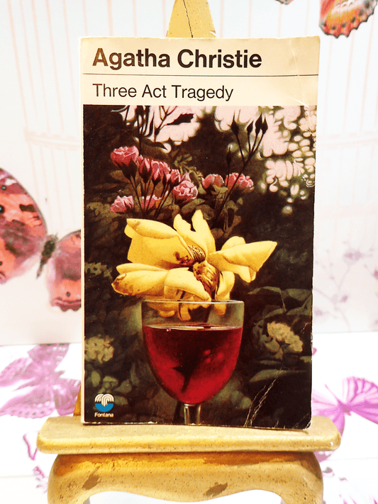 Front cover of Three Act Tragedy by Agatha Christie Vintage Pan Paperback Classic Crime book showing a flower with yellow petals in a glass of red wine. 