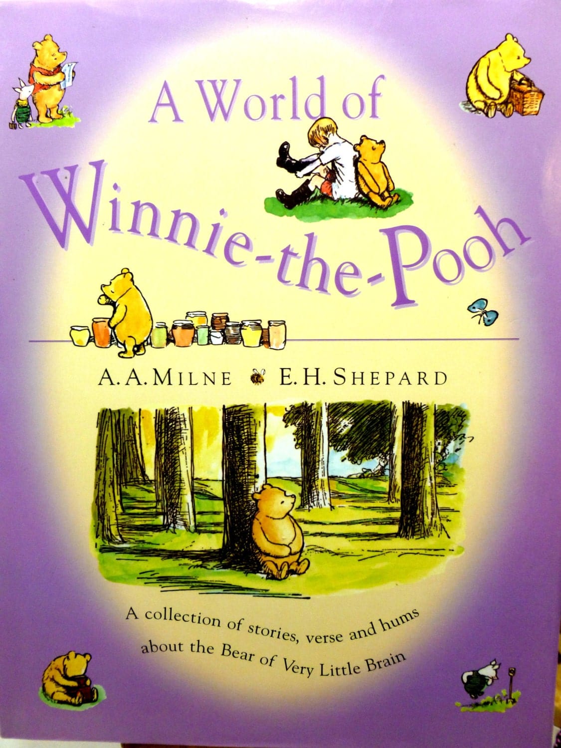 Front cover of A World of Winnie the Pooh Vintage Hardback Childrens Book illustrated with images of Christopher Robin and Pooh against a lilac ground. 